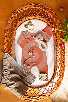 Pastel baby clothes and accessories in the basket bassinet.