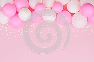 Pastel balloons and white confetti on pink background top view. Flat lay style.