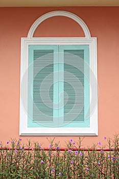 Pastel blue window with white frame on pink wall