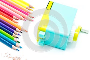 Pastel blue yellow rotary pencil sharpener shavings with wooden colorful pencils isolated on white background, back to school