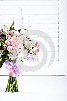 Pastel bouquet from pink and purple gillyflowers on white shutters background