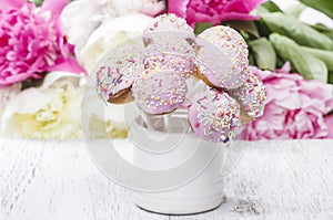 Pastel cake pops on rustic wooden table