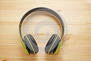 Pastel color headphones on wooden background, Modern electronic gadgets