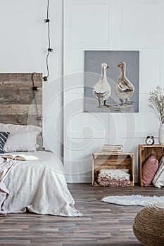 Pastel colored bedroom interior with wooden furniture in rustic style