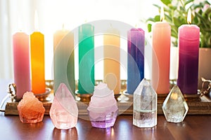 pastel-colored candles with healing crystals