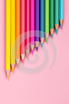 Pastel colored pencils close-up pink background vertical