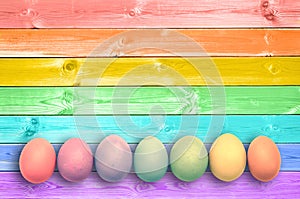 Pastel colorful rainbow painted eggs wood planks background