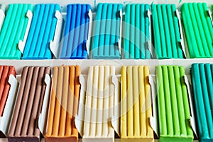 Pastel colors of modeling clay. Multicolored plasticine bars ina box, background texture