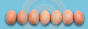 Pastel Easter eggs aligned, blue background