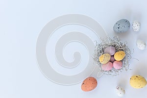 Pastel Easter eggs in nest on the white background.Flat lay style.