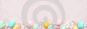Pastel Easter eggs and white spring flowers bottom border against a soft pink stone banner background