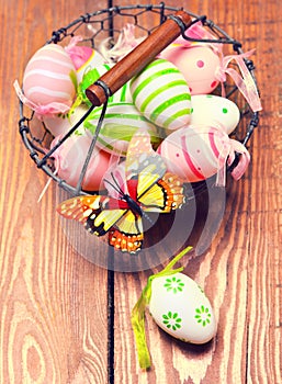 Pastel flowers, colorful Easter eggs in basket