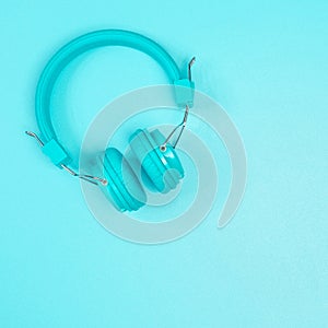 Pastel green headphone on pastel green metal table background.