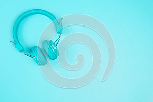 Pastel green headphone on pastel green metal table background.