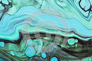 Pastel green waves with blue spots and gold sparkles. Acrylic Fluid Art. Abstract stone background or texture