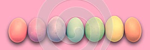 Pastel painted Easter eggs aligned in a row on pink panoramic background Easter web banner