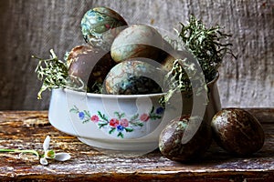 Pastel painted easter eggs in a white bowl.