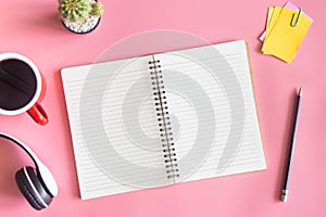 Pastel pink desk office with laptop, smartphone and other work supplies with cup of coffee. Top view with copy space for input the