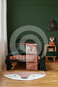 Pastel pink, orange and dark green colors in fashionable kid`s bedroom