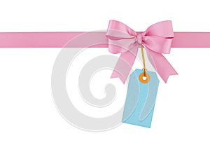 pastel pink ribbon with tied bow and blank blue price tag isolated on white background