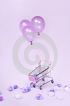 Pastel pink shopping cart floating with balloon on pink background