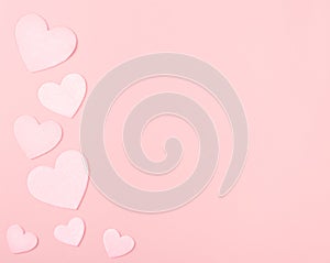 Pastel Pink Valentine Hearts on Pink Paper with space for copy, text or your words.  It`s a horizontal photo with an above view a