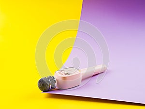 Pastel pink microphone on colorful background