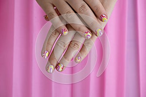 Pastel softness colorful manicured nails on pink background. Woman showing her new summer manicure in colors of pastel