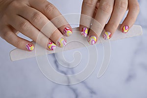 Pastel softness colorful manicured nails. Woman showing her new summer manicure in colors of pastel palette. Simplicity