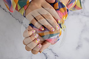 Pastel softness colorful manicured nails. Woman showing her new summer manicure in colors of pastel palette. Simplicity