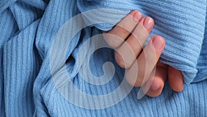 Pastel softness manicured nails on blue sweater background. Woman showing her new manicure in colors of pastel palette