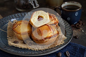 Pasticciotto leccese pastries on a dark blue plate near coffe cup on dark table close up