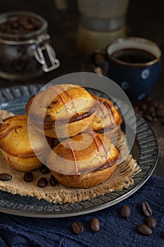 Pasticciotto leccese pastries on a plate near coffe cup and moka on dark table close up