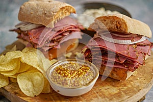 Pastrami sandwhich with delicious meet on baguette bread with chedder cheese, onion