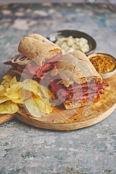 Pastrami sandwhich with delicious meet on baguette bread with chedder cheese, onion