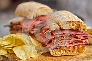 Pastrami sandwhich with delicious meet on baguette bread with chedder cheese, onion