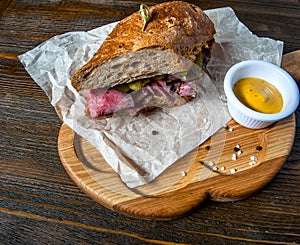 Pastrami sandwich on wooden plate