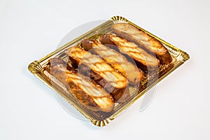 Pastries in a gold tray on white background