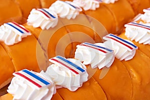 Pastries with orange icing glaze, whipped cream and dutch flags