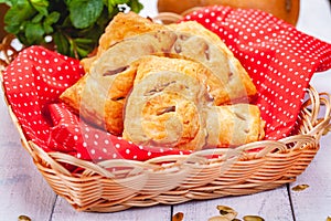 Pastry with apples and pumpkin seeds in basket on wooden table