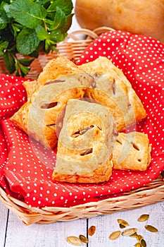 Pastry with apples and pumpkin seeds in basket on wooden table