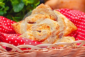 Pastry with apples and pumpkin seeds in basket on wooden table.