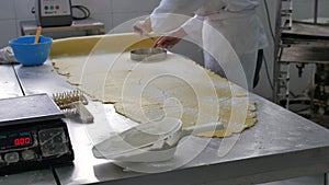 Pastry being cut from sheet in industrial bakery
