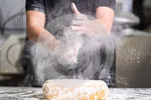 Pastry Chef clapping his hands with flour while making dough