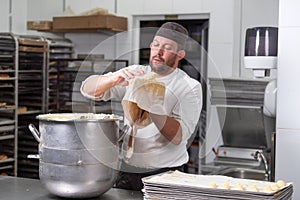 Pastry Chef with confectionary bag squeezing cream at pastry shop.