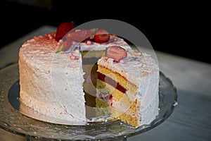 The pastry chef cut the cake. Strawberry yogurt cake. Consists of butter sponge cakes,covered with cream-based live