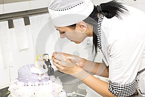 Pastry chef decorates a cake