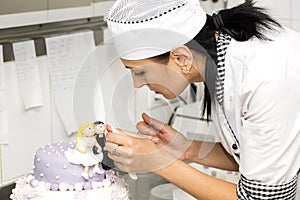 Pastry chef decorates a cake