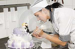 Pastry chef decorates a cake photo