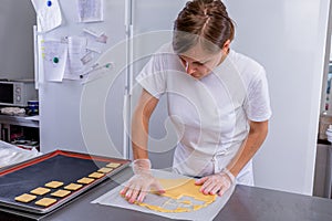 Pastry chef in the kitchen makes cookies. Cook cuts cookies from rolled dough using a cookie cutter. Master class in the kitchen.